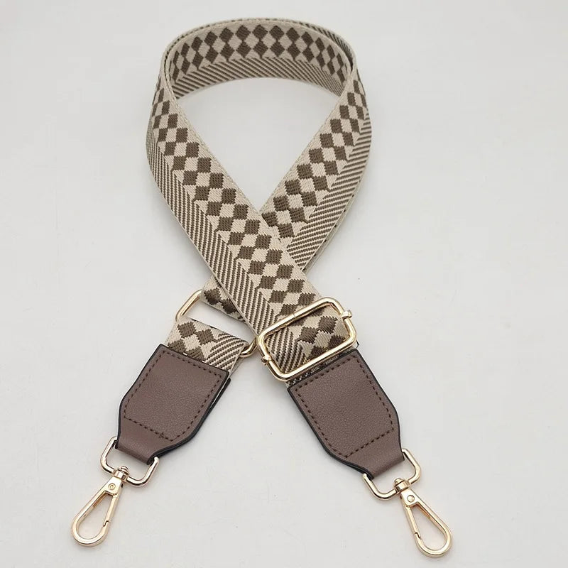 A beige and black checkered braided nylon bag strap with metal hooks.