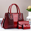 Set de bolso de cuero patentado con estampado de cocodrilo granate, incluye bolso principal y clutch.