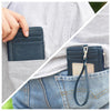 Eine Hand steckt eine dunkelblaue PU-Leder-Ausweiskartehülle mit einem schwarzen Lanyard in die Tasche einer blauen Jeans.