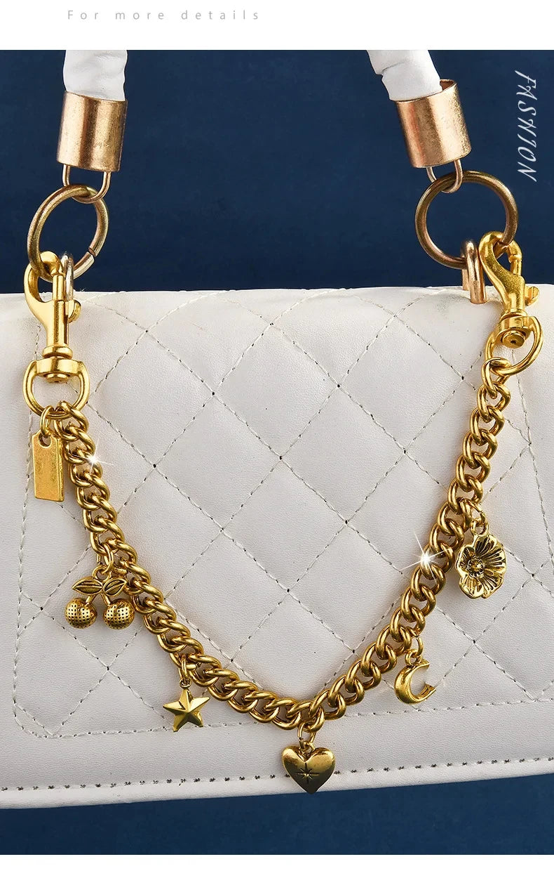 Gold chain necklace with a cherry flower pendant draped over a white quilted leather bag.