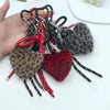 A collection of leopard print faux fur charm keychains in various shades of brown and red.