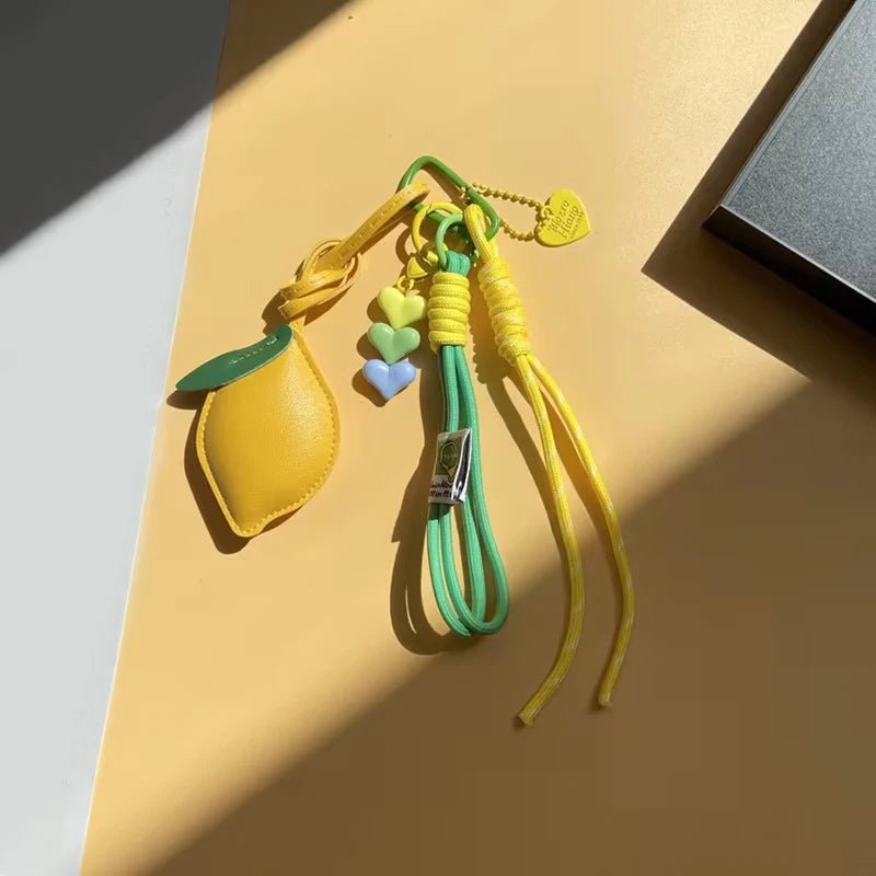 Yellow and green braided rope keychain with a heart-shaped leather charm