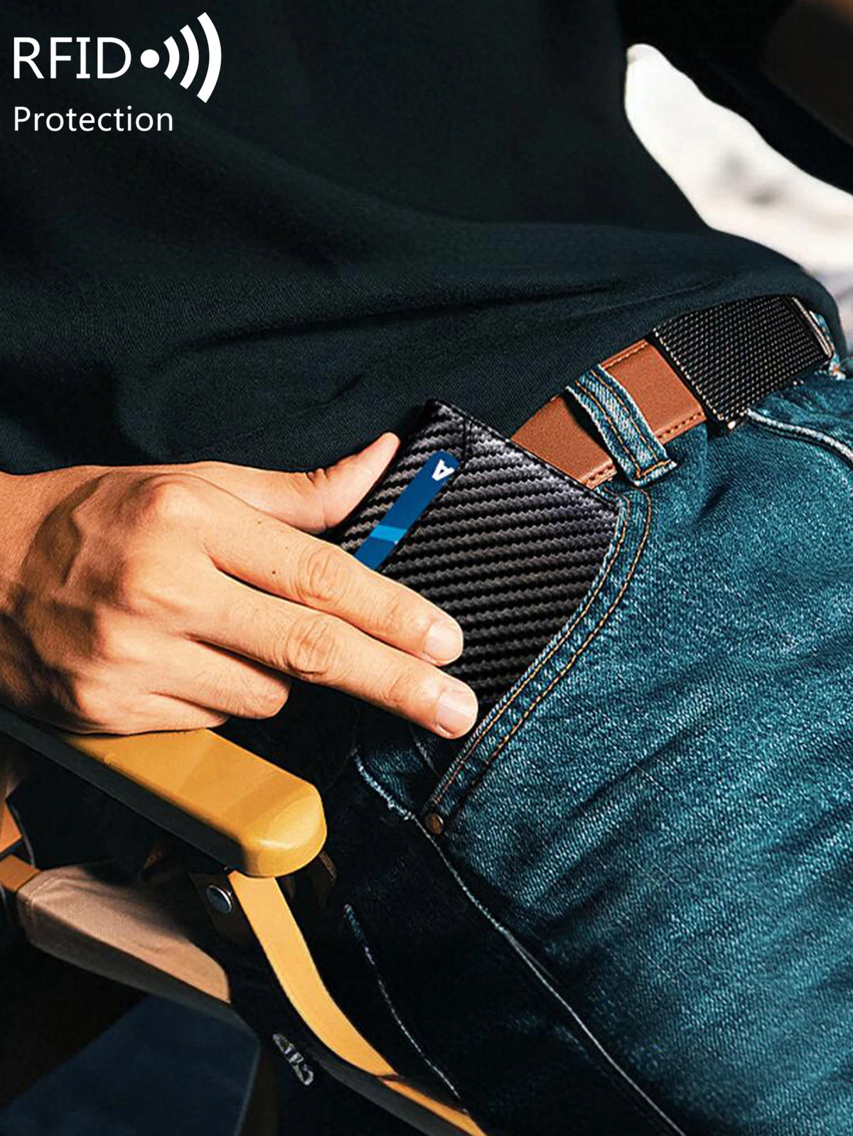 A hand is inserting an RFID blocking card into the front pocket of blue jeans.