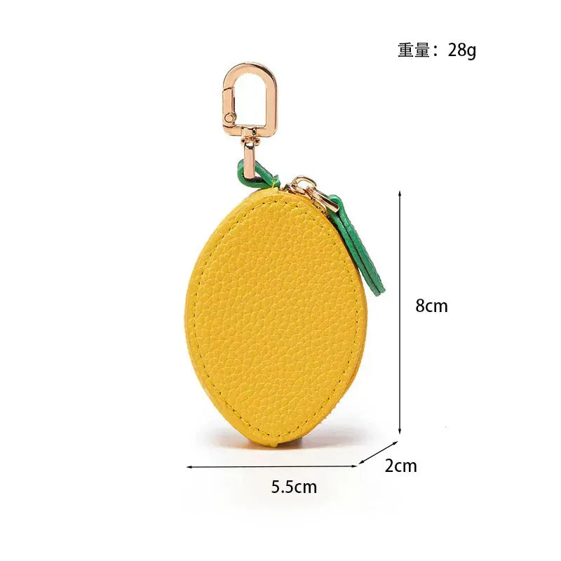 Yellow fruit-shaped PU leather coin purse keychain with a gold-colored clasp and green cord