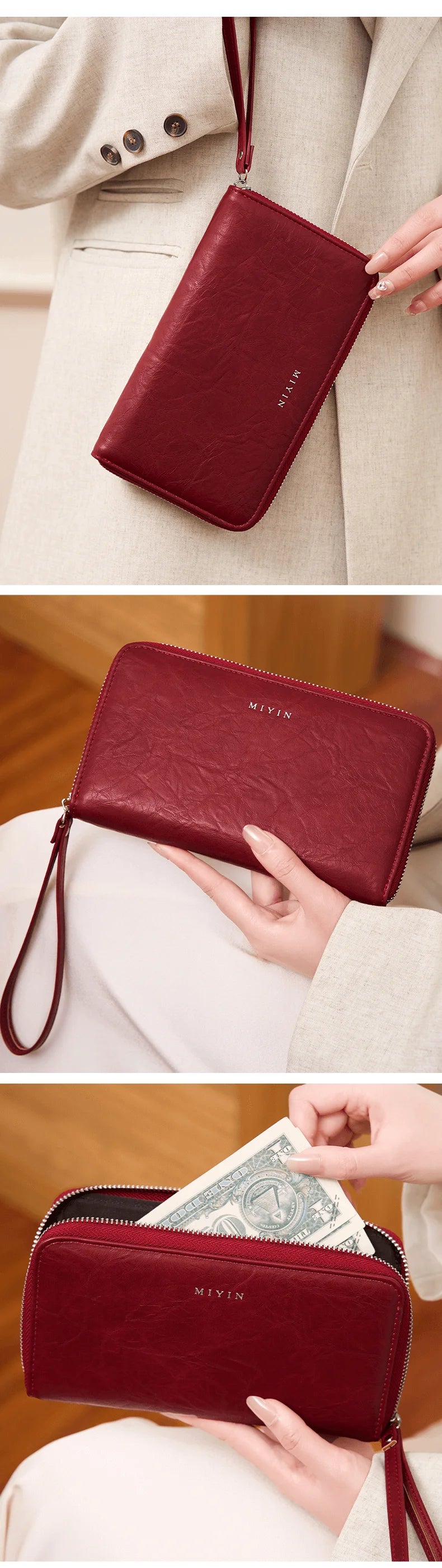 A close-up of a deep red leather wallet with a zipper closure and a leather strap, held by a hand.