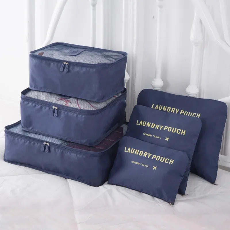 A set of navy blue laundry pouches and storage boxes for travel organization displayed on a white surface.