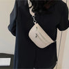 A beige PU leather multi-pocket crossbody bag is shown hanging from a black blouse.