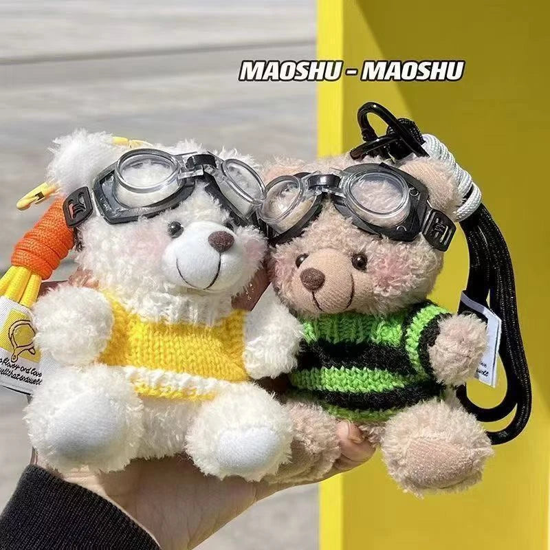 A fluffy white bear plush toy wearing black glasses and a yellow shirt, held against a yellow background.
