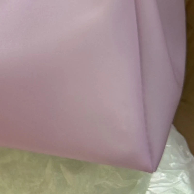 Vue rapprochée d'un sac en filet transparent lilas Y2K.