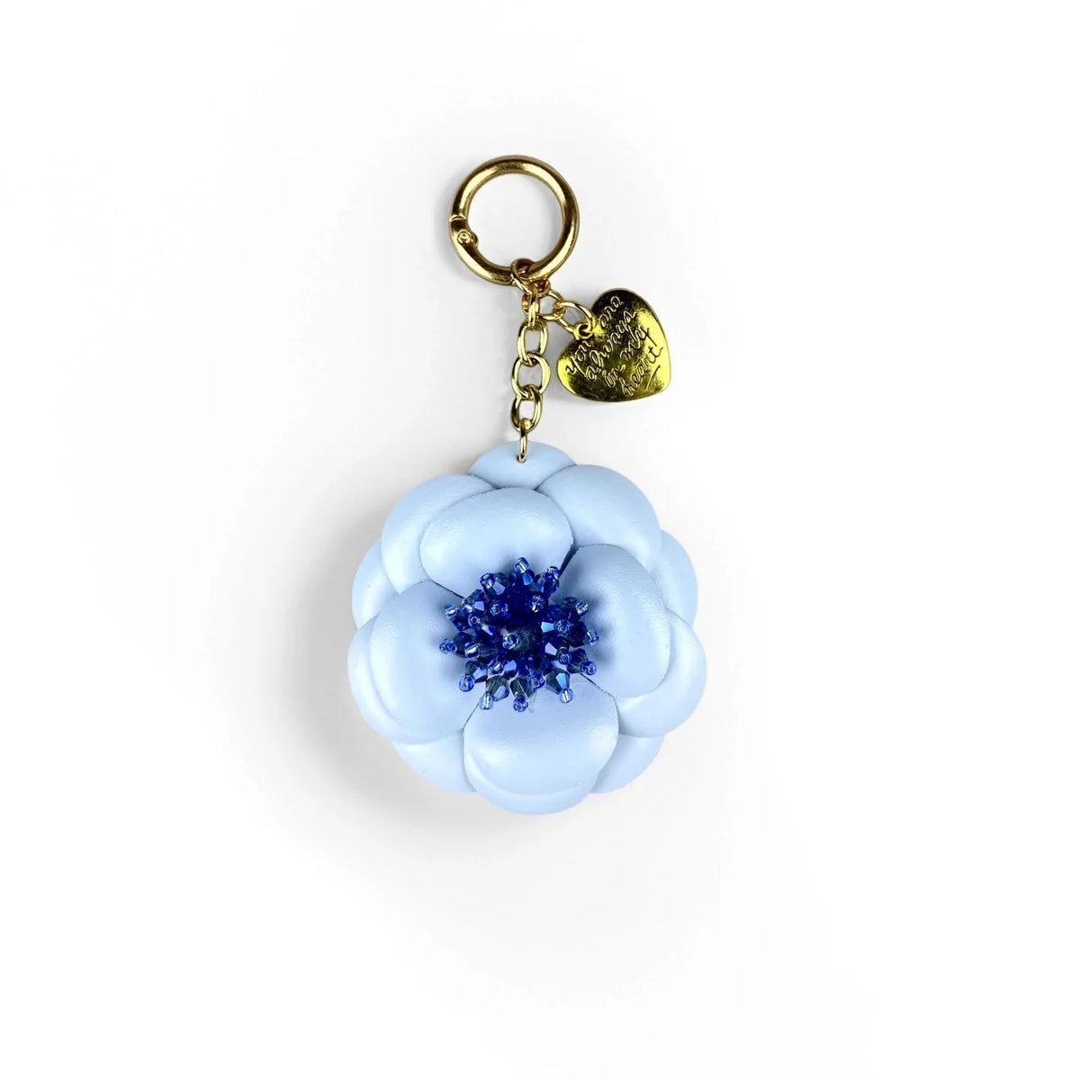 A gold-toned keychain featuring a light blue floral charm with a deep blue center.