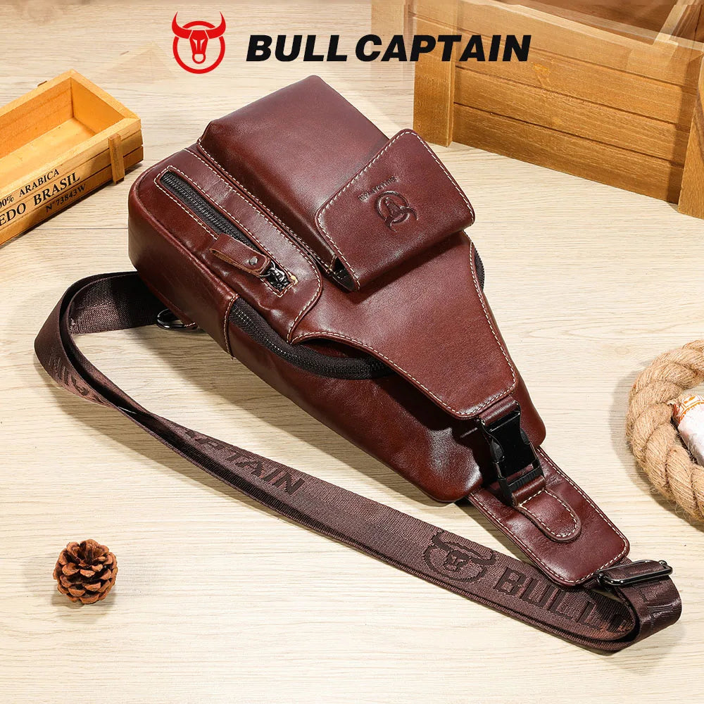 A brown genuine leather sling backpack with a dark brown strap is displayed on a wooden surface.