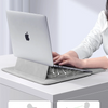 A laptop is placed on a stand designed to improve ventilation and dissipate heat.