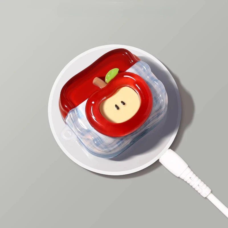 A red and yellow fruit design earphone case is shown on a white plate.