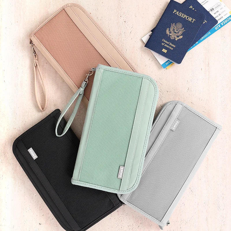Collection de porte-monnaie de voyage colorés, dont un organisateur rose, vert et noir, et un passeport.