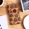 A patterned bohemian wood-grain leather wallet with multiple card slots resting on a light wooden surface.