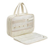 Sac organisateur de maquillage portable de couleur crème avec section supérieure transparente et couvercle amovible.
