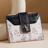 A black and white floral patterned PU leather slim card holder wallet with a black leather flap.