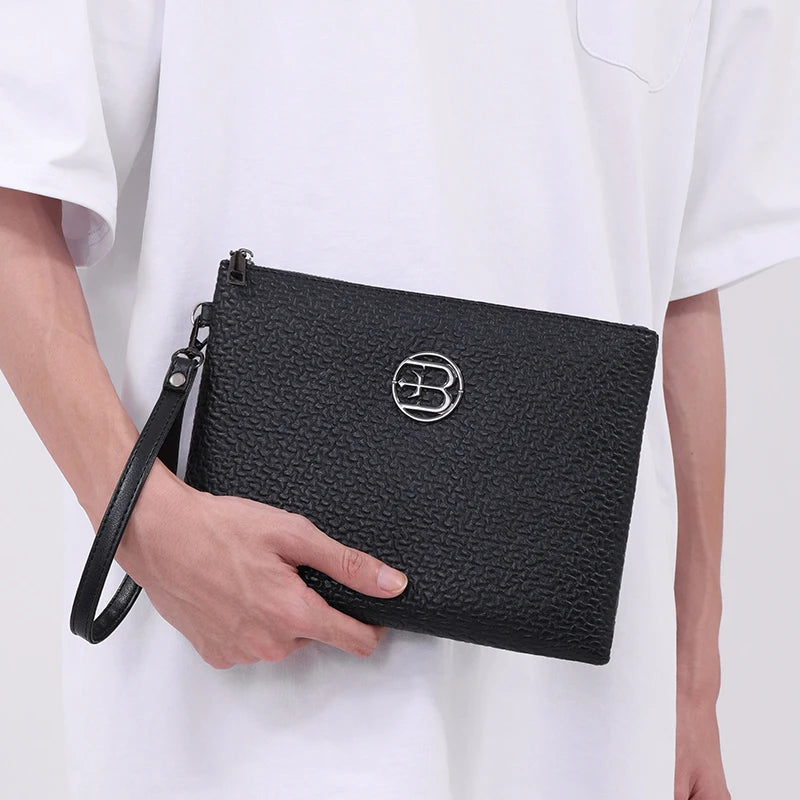 Schwarze Kunstleder-Clutchtasche für Herren mit silbernem Logo, gehalten von einer Person in einem weißen Hemd.