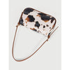 A single shoulder bag featuring a cow print pattern in beige and brown on a tan background.
