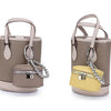A handcrafted leather neck pendant coin purse in beige and yellow with a silver chain lanyard.