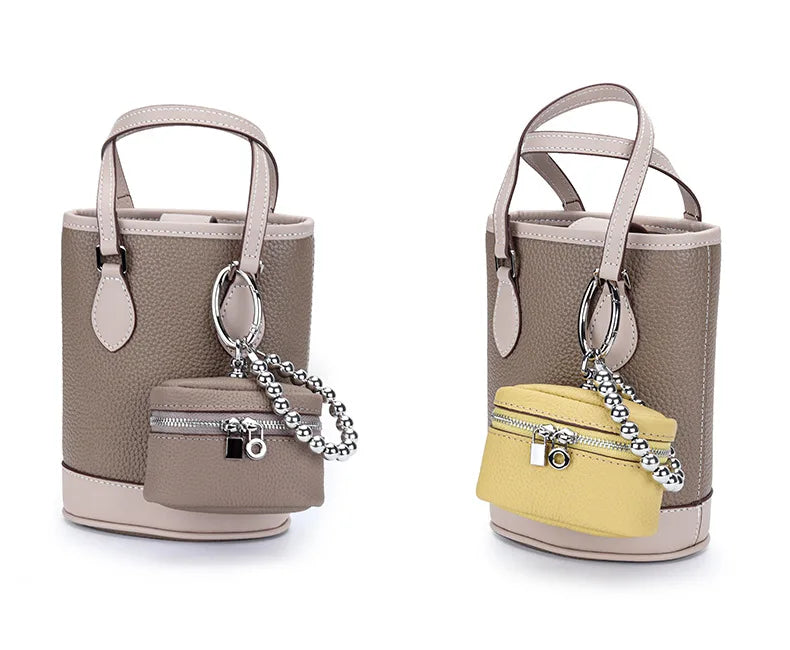 A handcrafted leather neck pendant coin purse in beige and yellow with a silver chain lanyard.