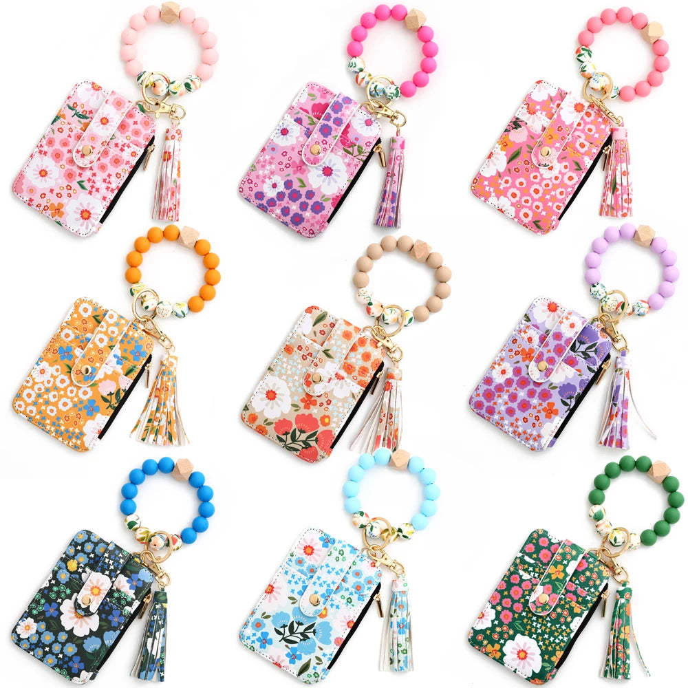 A collection of silicone bead PU leather key chain wallets featuring various floral patterns and colors.