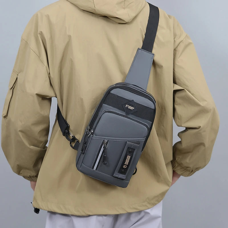 A tan jacket is shown with a gray nylon crossbody sling bag attached to the shoulder strap.