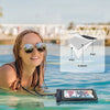 A woman wearing sunglasses is in water with a waterproof phone case floating on the surface.