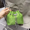 A hand holds a bright lime green crystal-embellished evening clutch with a silver chain.