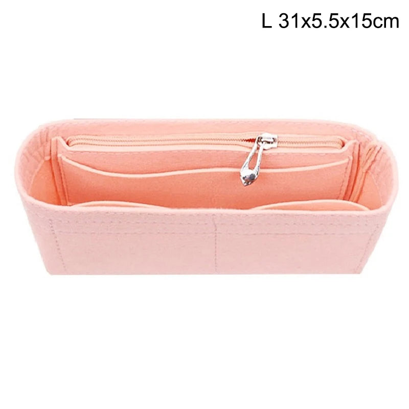 A pink felt bag insert organizer with a zipper closure for organizing small items in a handbag.