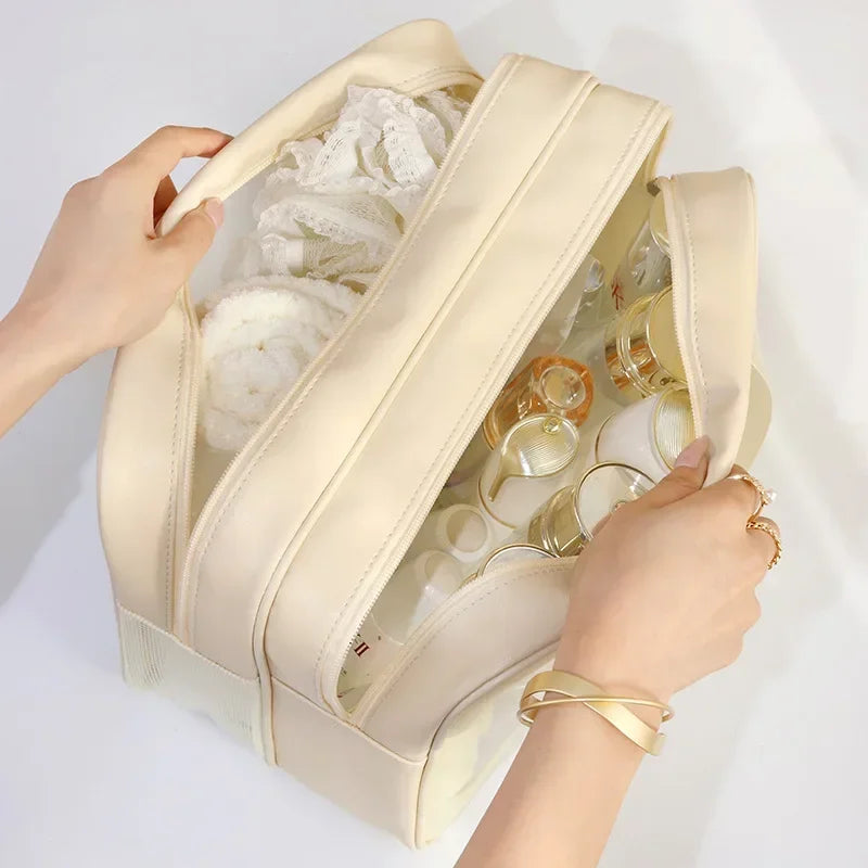 Una bolsa de maquillaje y tocador beige de separación húmedo-seco sostenida por una mano.