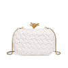 A white handwoven clutch evening bag with gold hardware is shown against a white background.