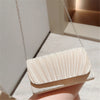 A luxury chain shoulder clutch bag in a pale beige color is displayed against a light background.