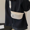 A black blazer features a cream leather multi-pocket crossbody bag with a white patterned strap.