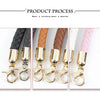 Close-up view of replaceable leather bag handles in various colors, including black, brown, white, and pink, attached to meta