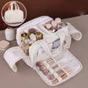 A beige portable side-zip cosmetic organizer bag with a matching handbag is shown open, displaying various makeup and jewelry
