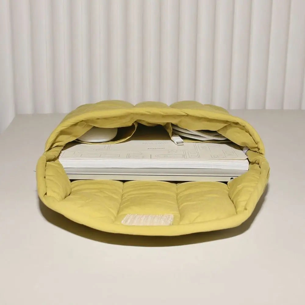 A yellow embroidered cotton laptop sleeve with a soft interior is shown on a white surface.
