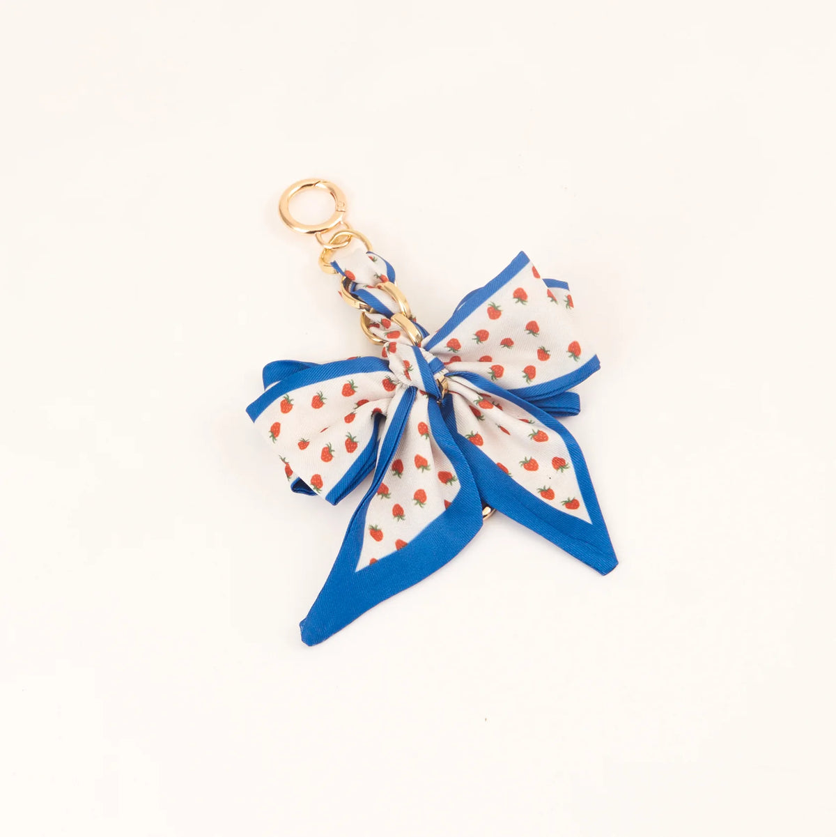 Lazo de cinta floral de seda azul y blanco con anillo metálico dorado para llavero.