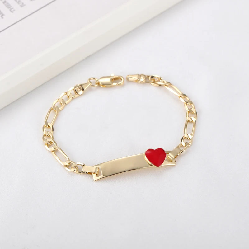 Gold chain bracelet with a red heart charm on a white background.