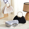 A set of elegant satin pleated evening clutch bags in silver and black, displayed on a light surface.