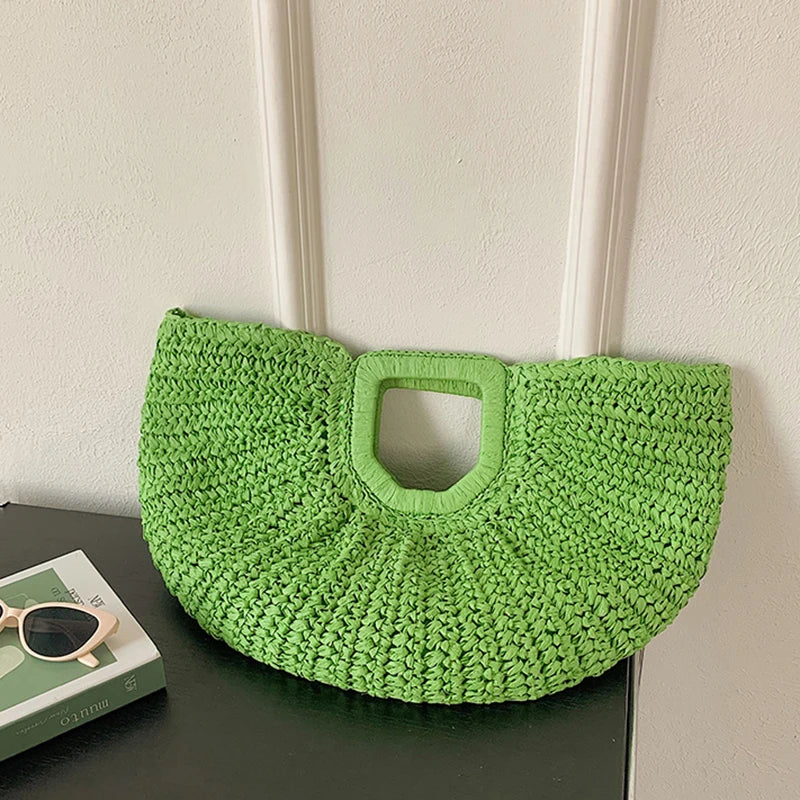 A bright lime green rattan half-moon beach handbag hanging on a white wall.