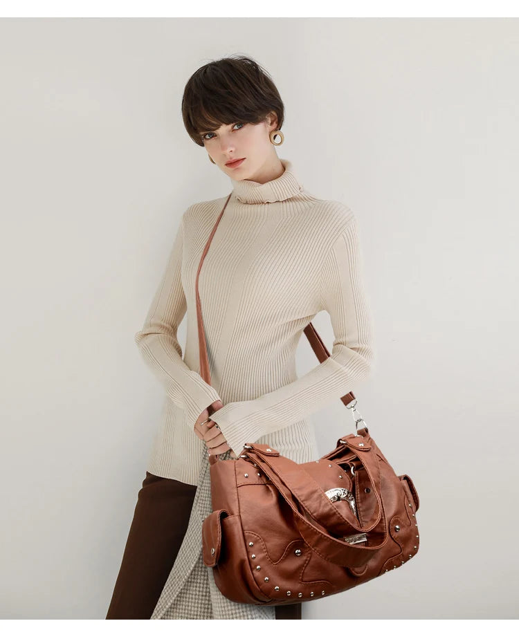 Eine Frau präsentiert einen braunen Vintage-Soft-PU-Leder-Schultertasche und einen braunen Rollkragenpullover.
