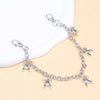 Silver metal purse chain strap with charm detailing laid out on a light background.