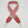 A braided nylon bag strap in red and white checkered pattern with gold-toned metal hooks.