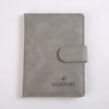 Porte-passeport en cuir gris avec rabat et le mot PASSPORT gravé.