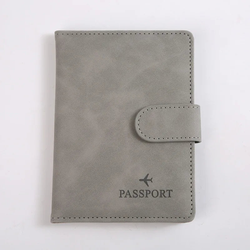Porte-passeport en cuir gris avec rabat et le mot PASSPORT gravé.