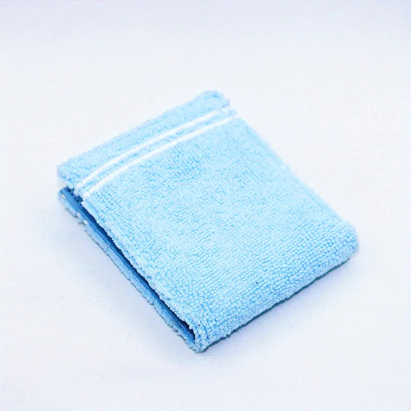 A folded light blue fabric wallet with embroidered details on a white background.