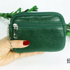 A hand holds a dark green compact PU leather mini wallet with a silver keychain.