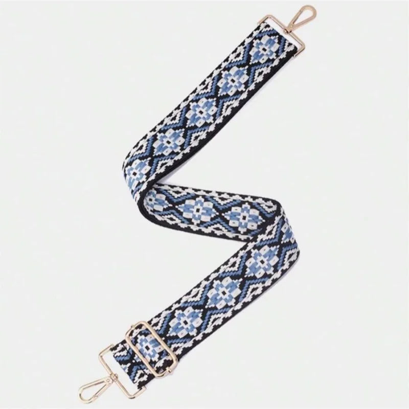 A patterned blue and white fabric strap with gold hardware, shown diagonally.