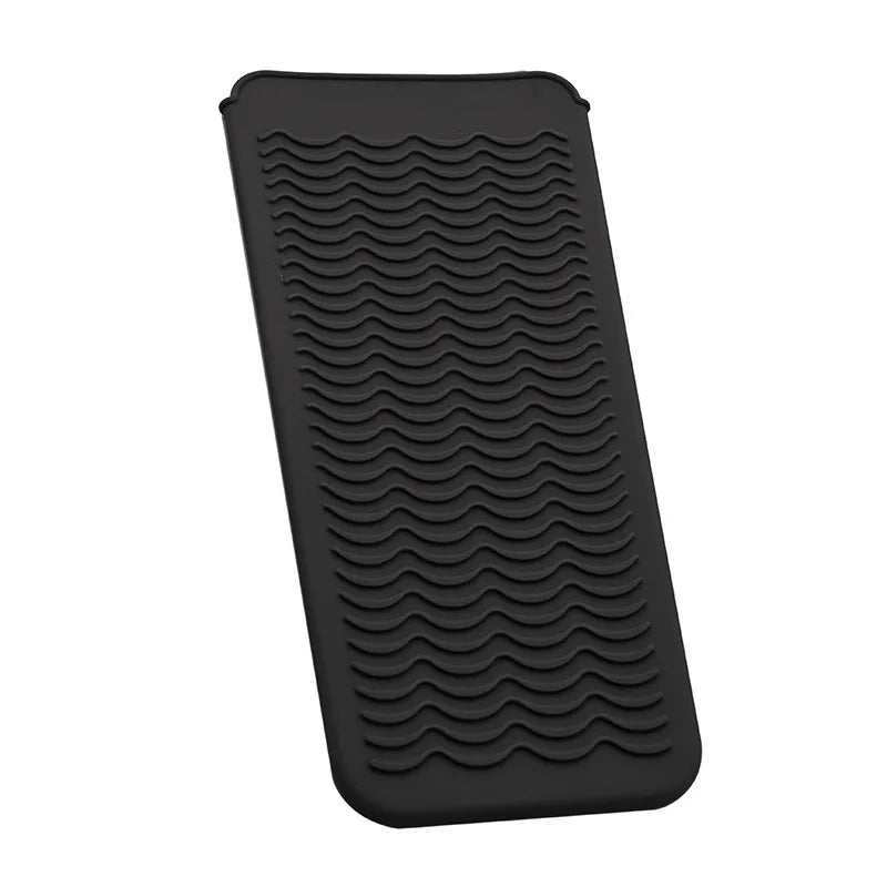 Black heat-resistant silicone mat with a textured, wavy pattern for styling tools